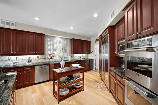 a kitchen with stainless steel appliances granite countertop a stove a sink and a microwave