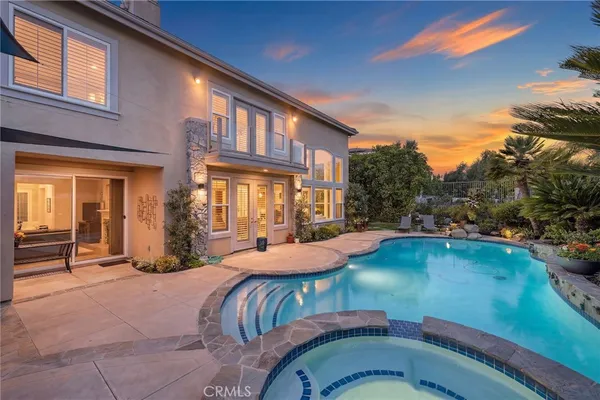 a view of a house with swimming pool and sitting area