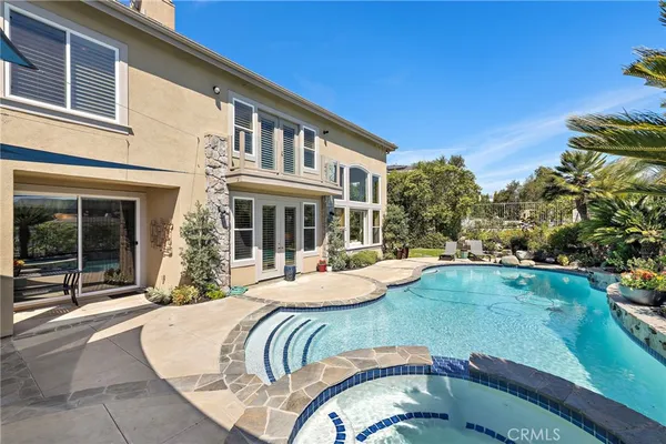 a view of a house with swimming pool and porch with furniture