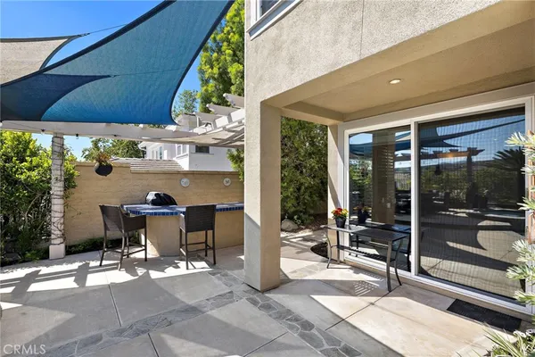 a view of a patio with table and chairs potted plants with floor to ceiling window and potted plants