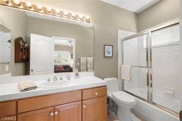 a bathroom with a shower sink vanity and mirror