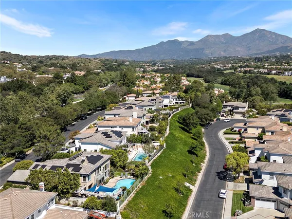 an aerial view of a house with a garden and lake view