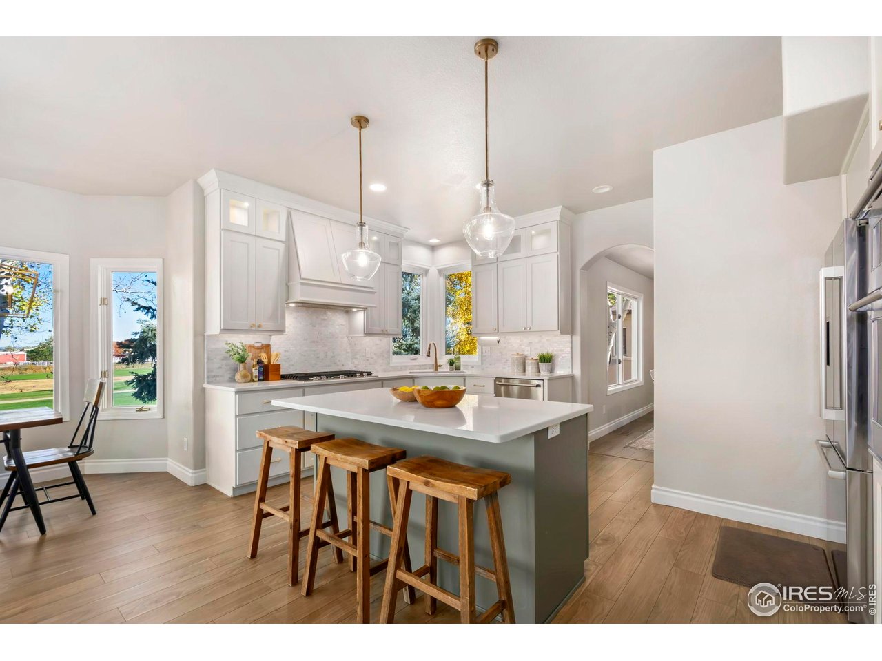 5256 Augusta Trail Fort Collins, CO 80528 - Photo 11 of 50 a kitchen with kitchen island a stove a table a sink refrigerator and cabinets