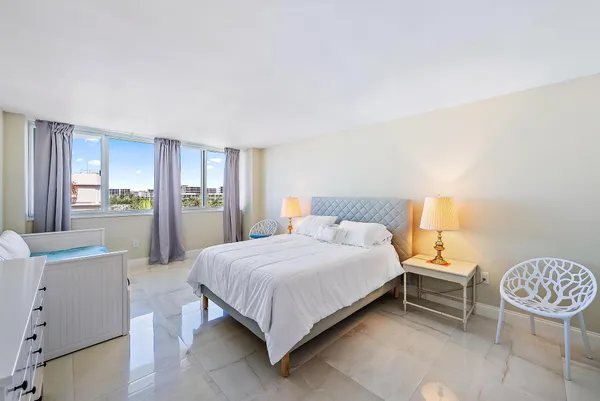 a bedroom with a bed a dresser and a window