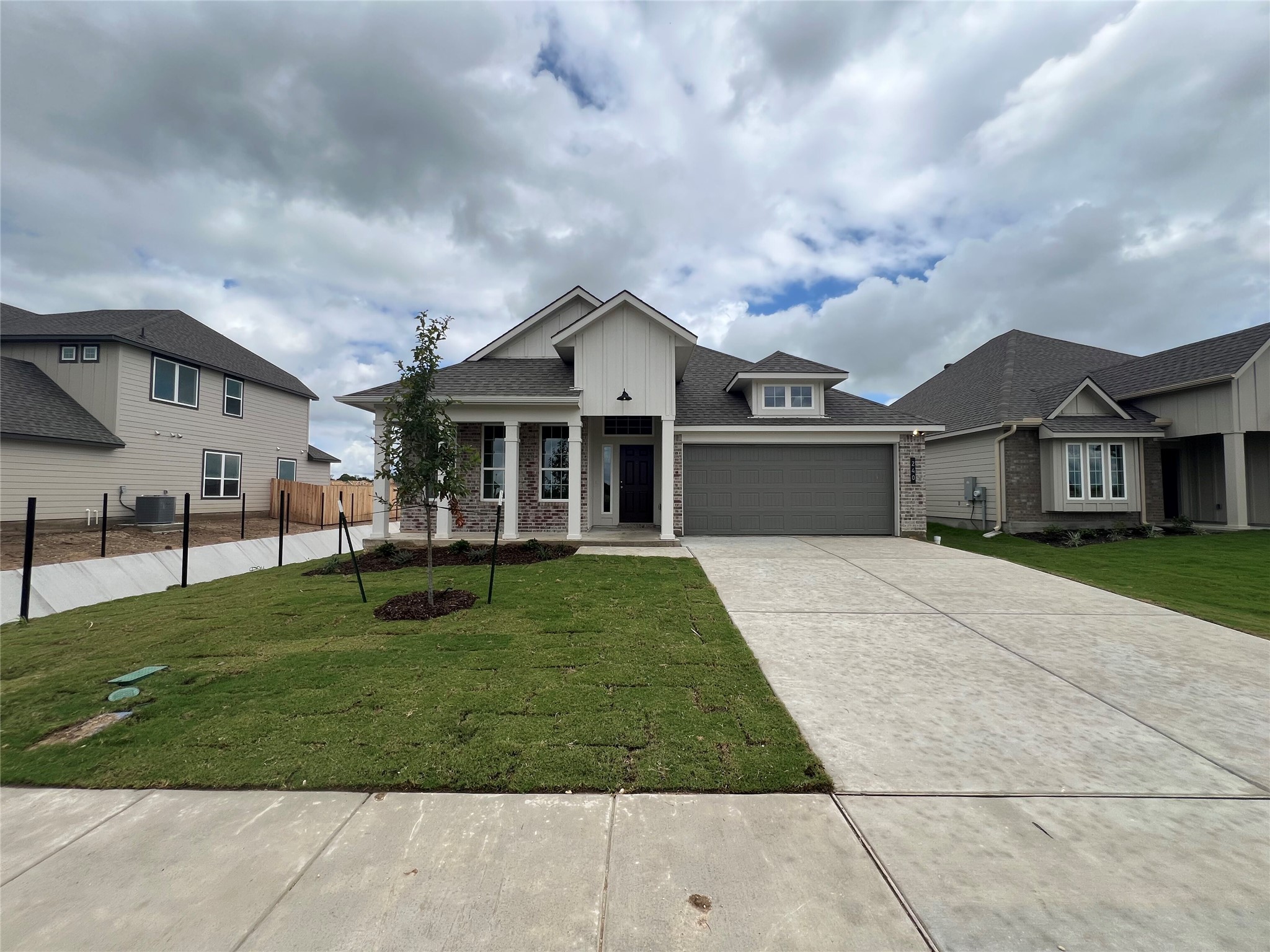 A well-maintained lawn and concrete driveway lead to this charming single-story residence.