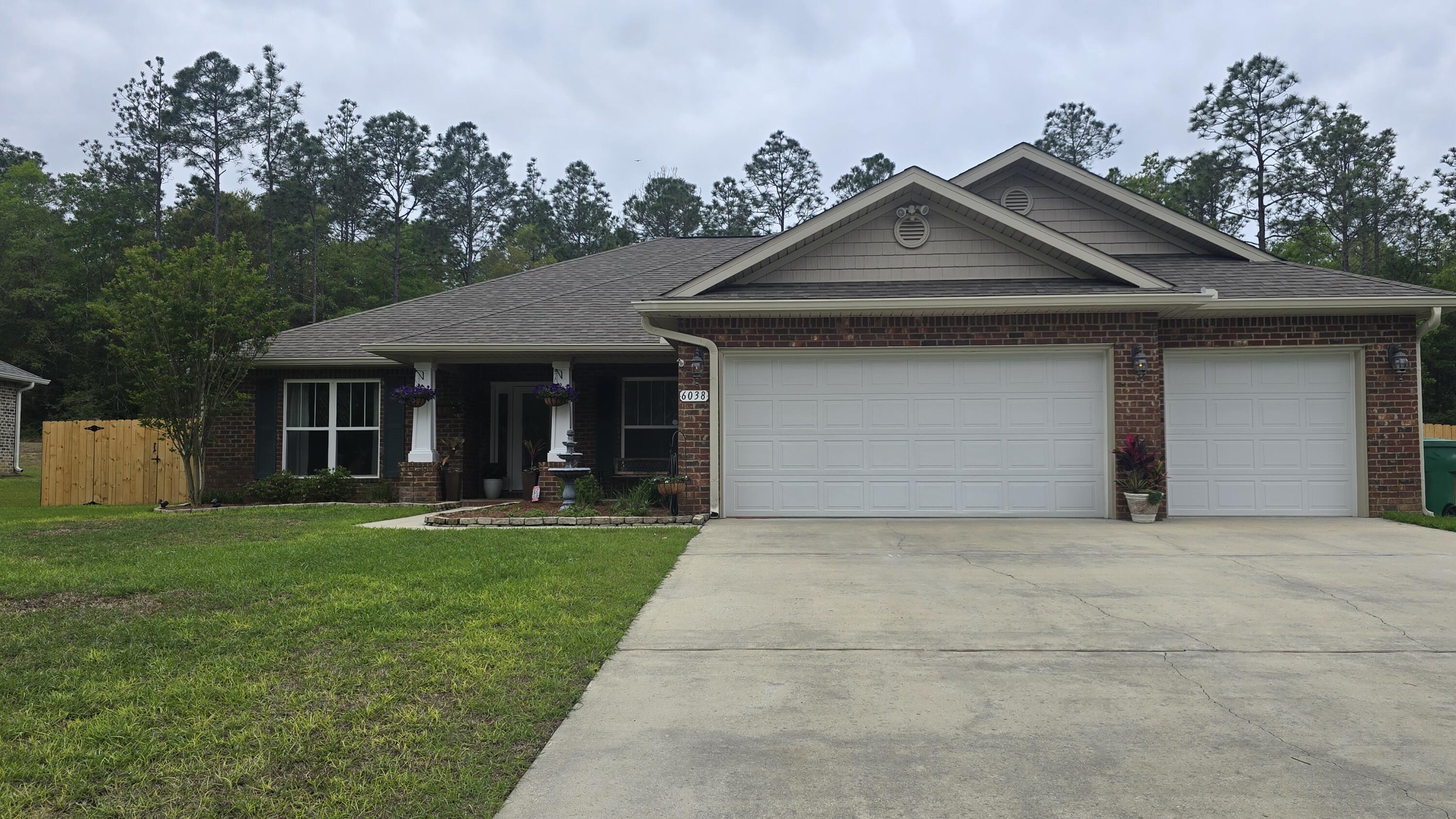 a front view of a house with a garden and trees