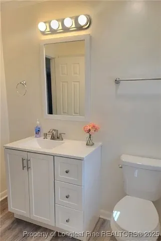 a bathroom with a toilet a sink a vanity and mirror