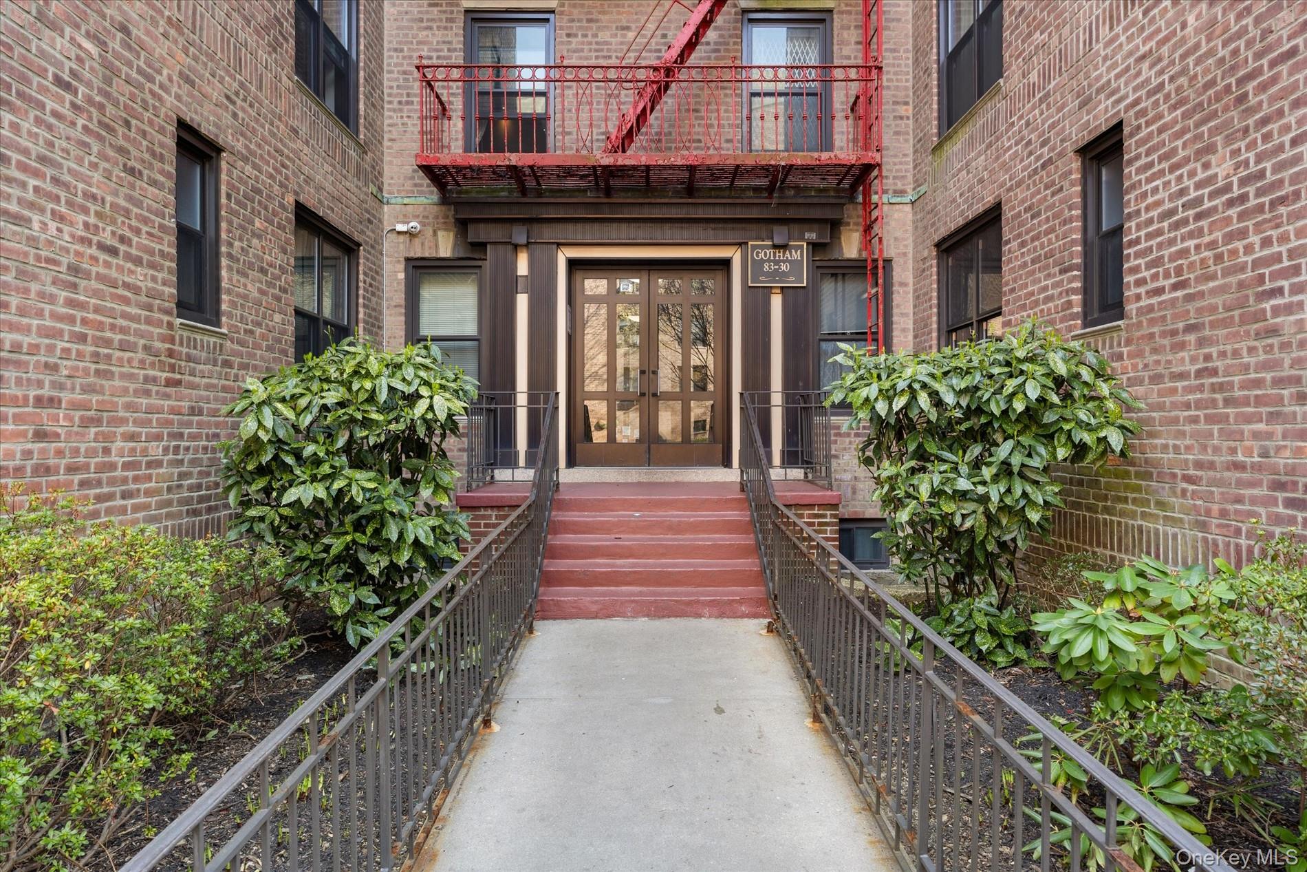 83-30 98th Street, Unit 1H Queens, NY 11421 - Photo 16 of 18 a front view of a multi story building with a yard