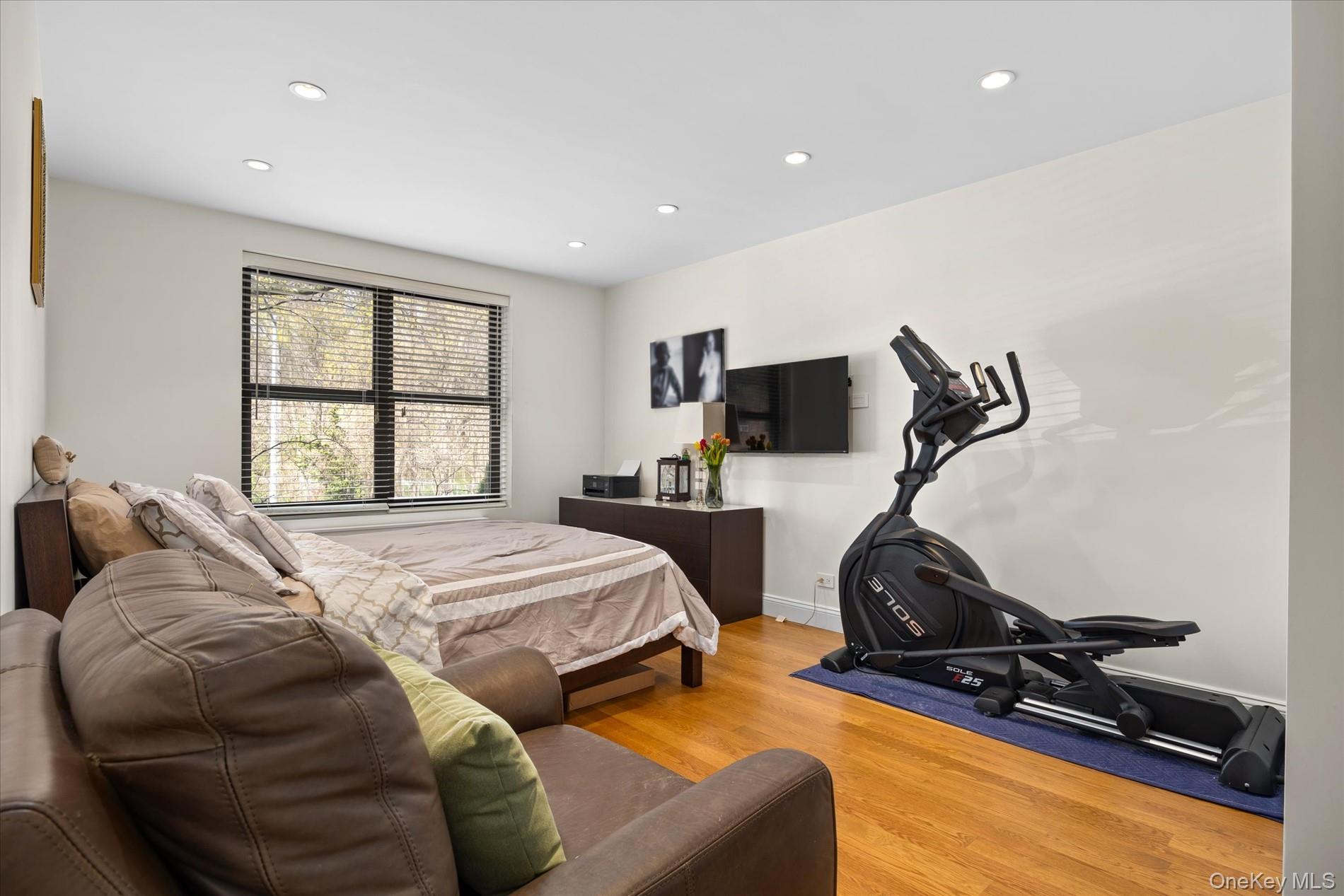 83-30 98th Street, Unit 1H Queens, NY 11421 - Photo 10 of 18 a bed room with furniture and a flat screen tv
