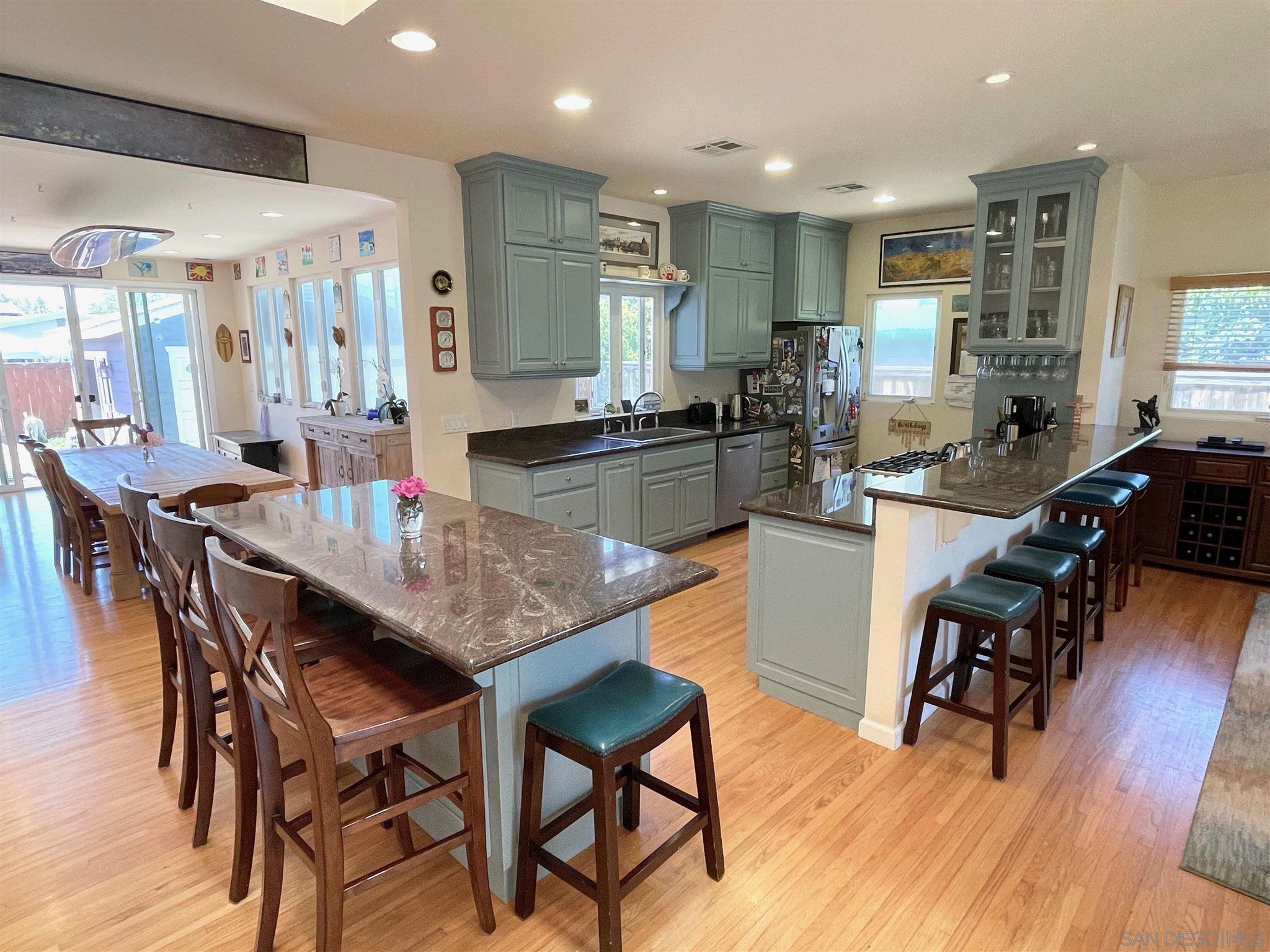 950 Cabrillo Avenue Coronado, CA 92118 - Photo 12 of 31 a kitchen with stainless steel appliances kitchen island granite countertop wooden floor dining table and chairs