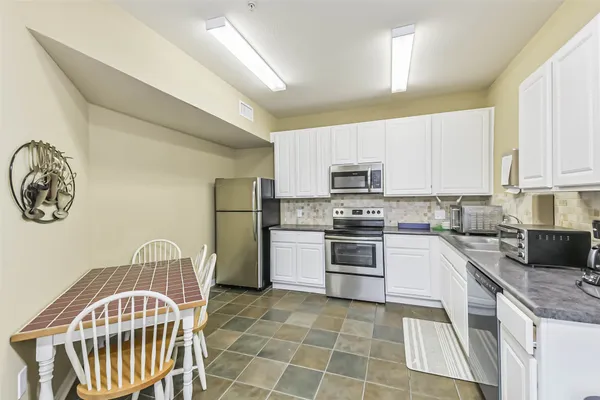 a kitchen with a sink a stove a microwave and cabinets