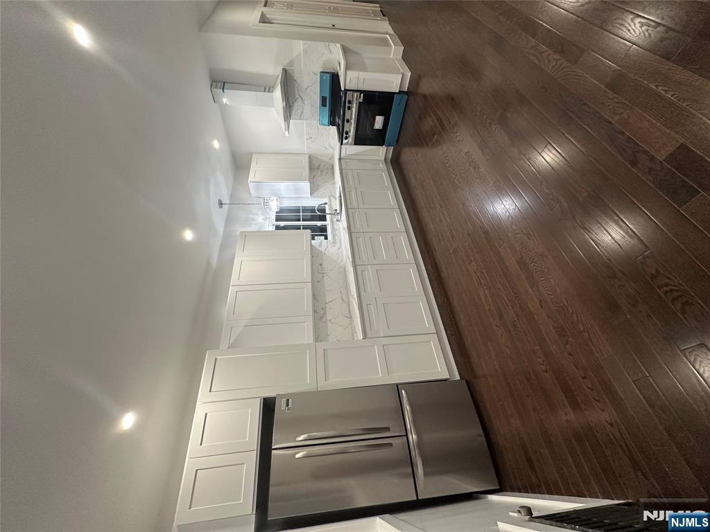 34 Garretson Avenue, Unit 2 Bayonne, NJ 07002 - Photo 3 of 12 a large kitchen with a center island wooden floor and stainless steel appliances