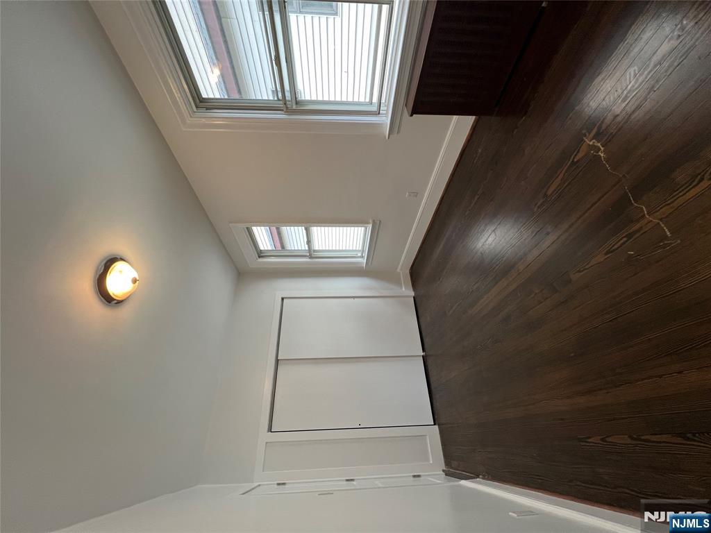 34 Garretson Avenue, Unit 2 Bayonne, NJ 07002 - Photo 7 of 12 an empty room with wooden floor and windows