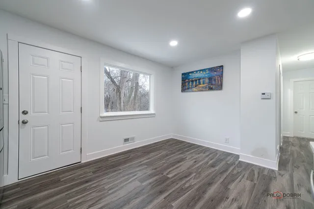 a bathroom with a granite countertop sink a toilet and a window