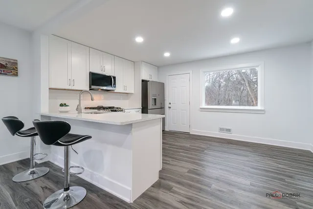 a kitchen with a refrigerator and a stove top oven