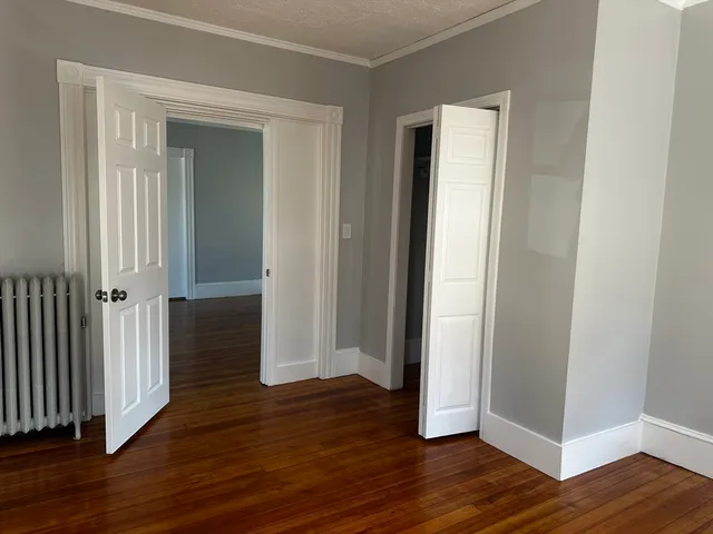 an empty room with wooden floor and closet