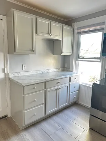 a kitchen with granite countertop white cabinets and sink