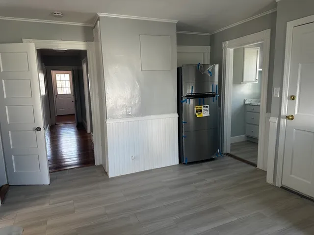 a view of empty room with wooden floor