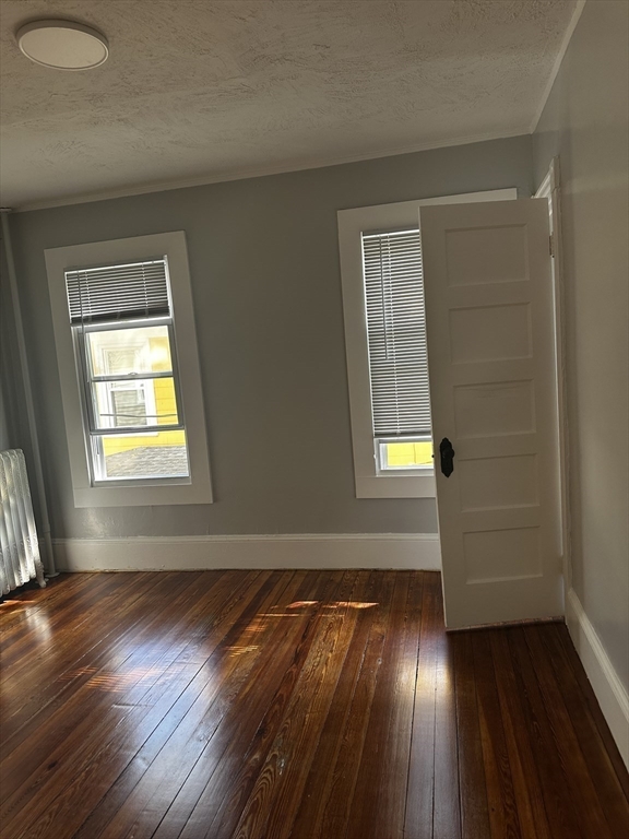 4 Howard Avenue, Unit 2 Attleboro, MA 02703 - Photo 9 of 17 a view of an empty room with wooden floor and a window