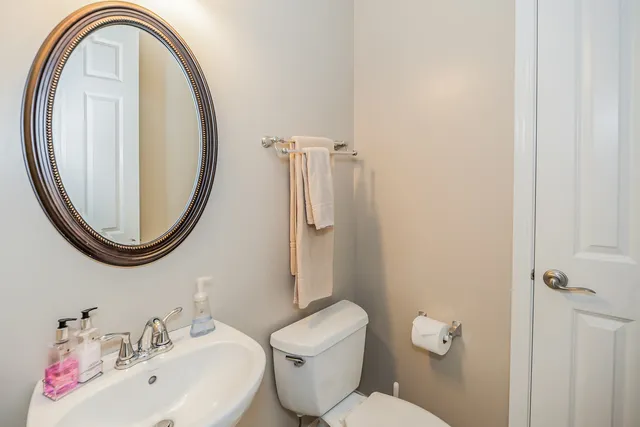 a bathroom with a toilet a sink and a mirror