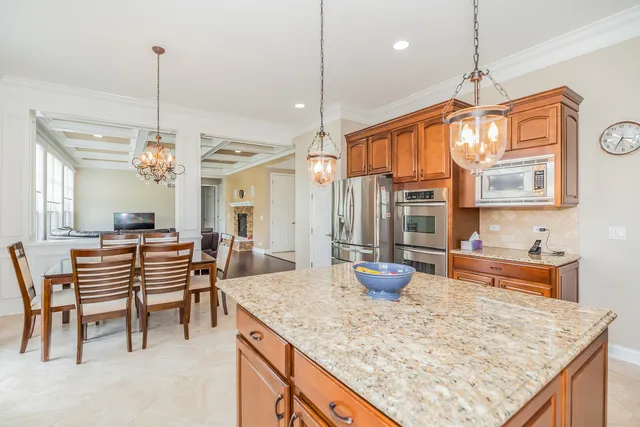 a kitchen with sink refrigerator dining table and chairs
