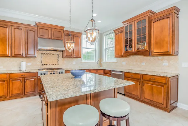 a kitchen with stainless steel appliances granite countertop a sink a microwave cabinets and a dining table