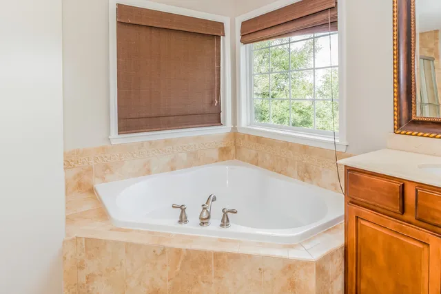 a white bath tub sitting in a bathroom next to a window