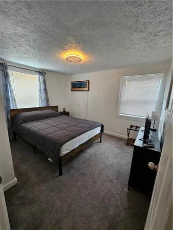 a bedroom with a bed and a black mirror