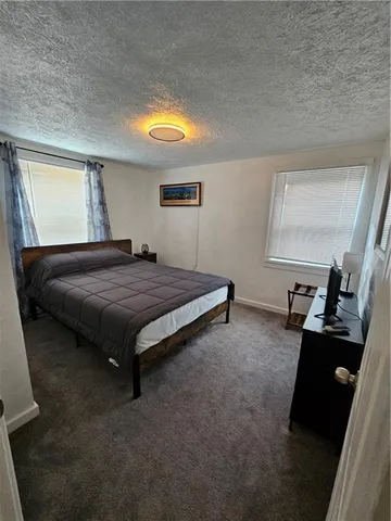 a bedroom with a bed and a black mirror