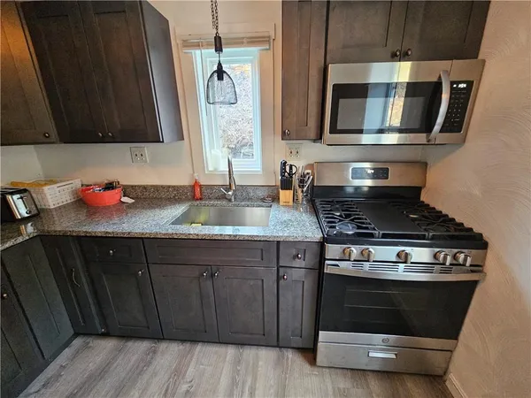 a kitchen with stainless steel appliances granite countertop a sink stove and refrigerator