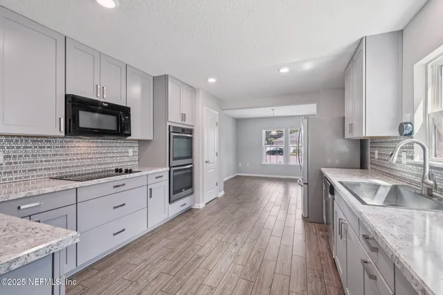 a view of an empty room with wooden floor and a ceiling fan