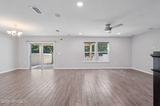 a view of a kitchen with wooden floor and a window
