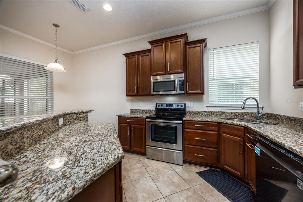 8216 Northwest 54th Street Gainesville, FL 32653 - Photo 30 of 58 a kitchen with stainless steel appliances granite countertop a sink stove and oven