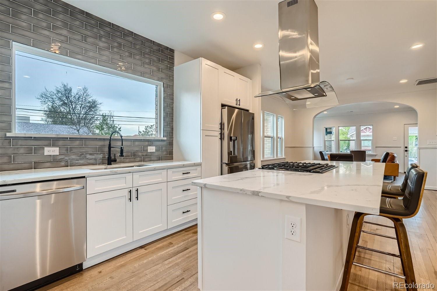 1400 Perry Street Denver, CO 80204 - Photo 11 of 26 a kitchen with stainless steel appliances kitchen island a table chairs sink and cabinets