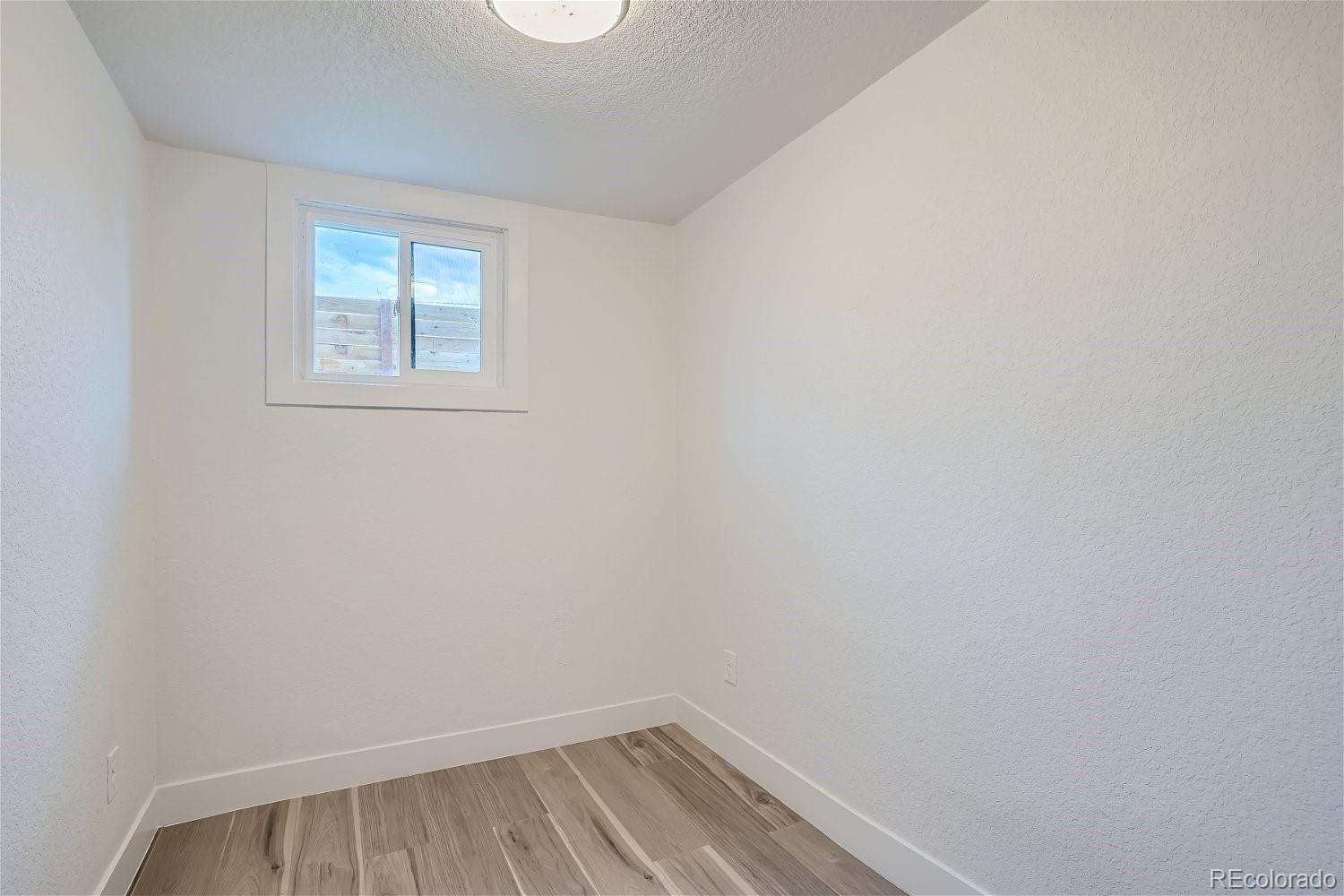 1400 Perry Street Denver, CO 80204 - Photo 20 of 26 a view of an empty room with wooden floor and a window