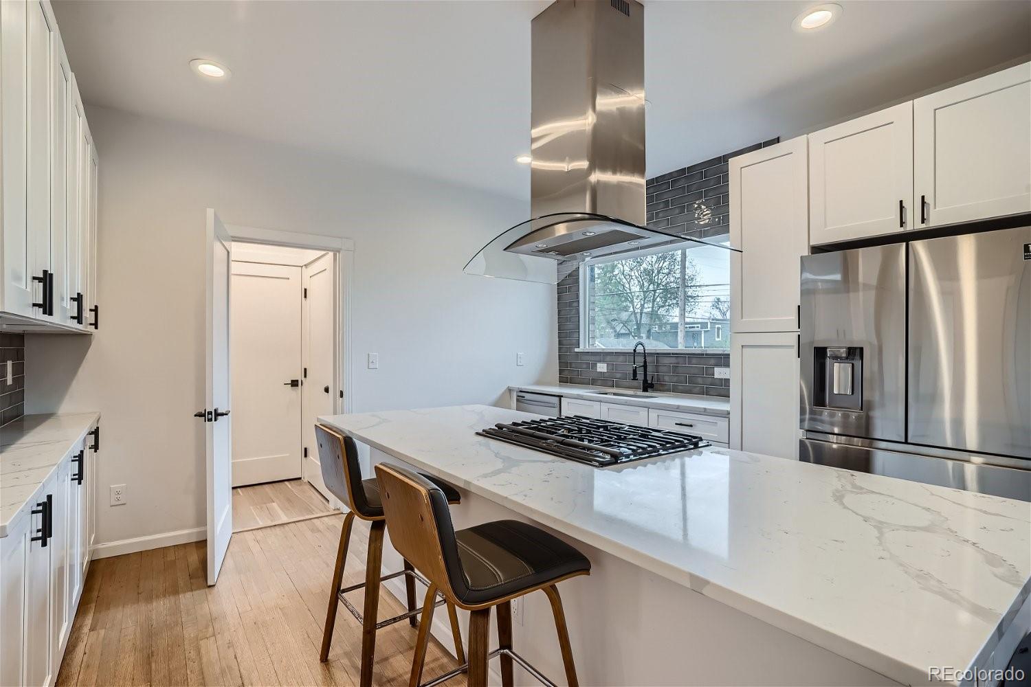 1400 Perry Street Denver, CO 80204 - Photo 9 of 26 a kitchen with stainless steel appliances granite countertop a stove a refrigerator and a stove top oven