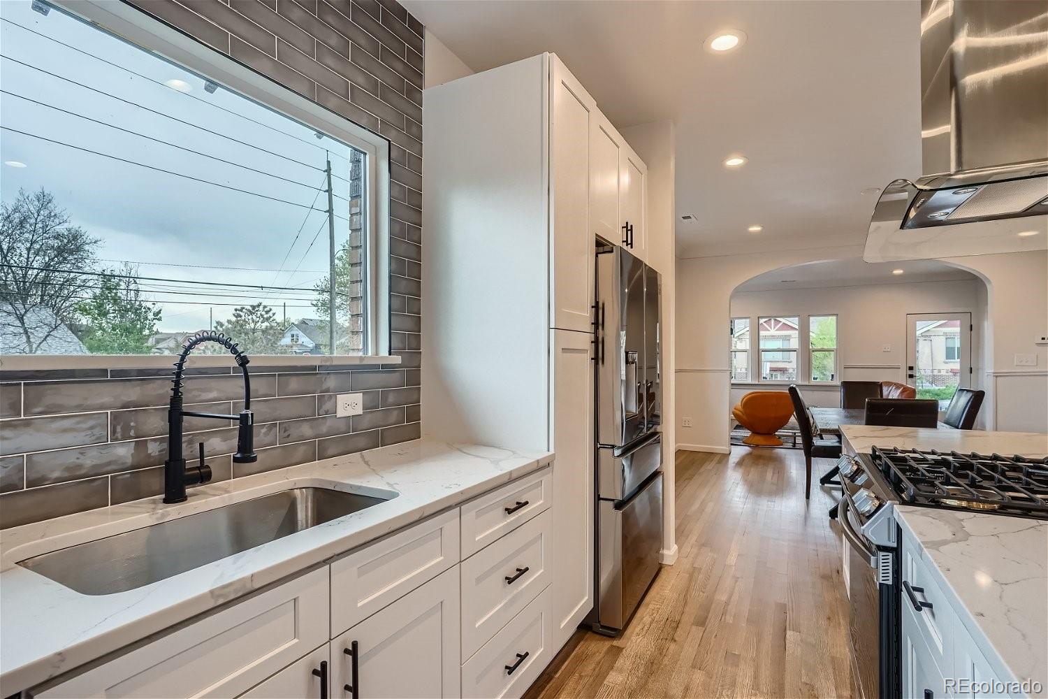 1400 Perry Street Denver, CO 80204 - Photo 10 of 26 a kitchen with stainless steel appliances granite countertop a sink a stove and a refrigerator