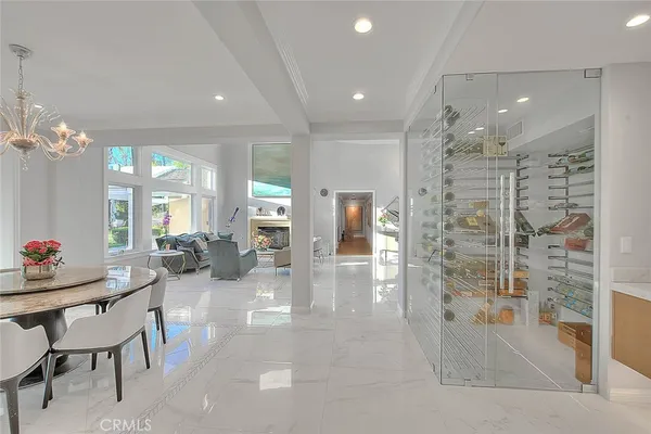 a large white kitchen with kitchen island a sink a stove and a refrigerator with wooden floor