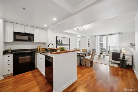 a kitchen with sink a microwave and cabinets