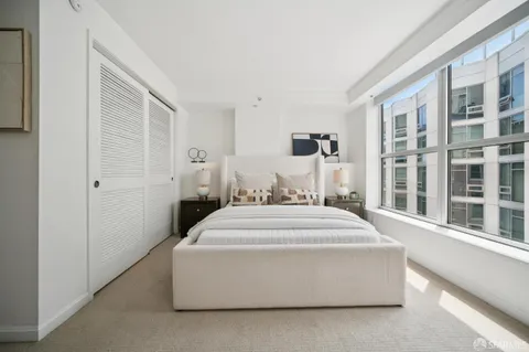 a spacious bedroom with a bed and a large window