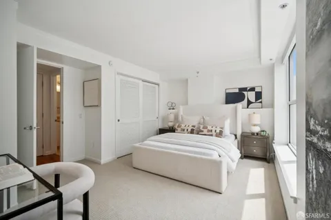 a bedroom with a bed and a table chair