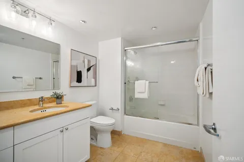 a bathroom with a sink and mirror with toilet