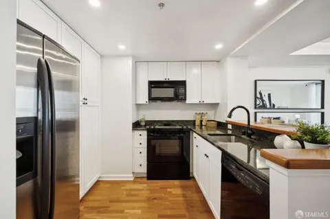 a kitchen with stainless steel appliances granite countertop a stove a sink and a refrigerator