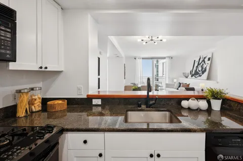 a kitchen with granite countertop a sink a stove and cabinets