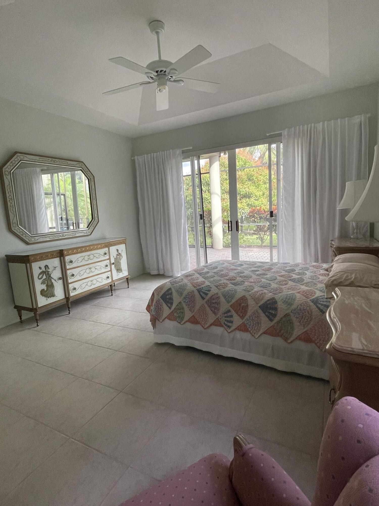 22324 Rushmore Place Boca Raton, FL 33428 - Photo 19 of 33 a bedroom with a bed a chandelier and a window