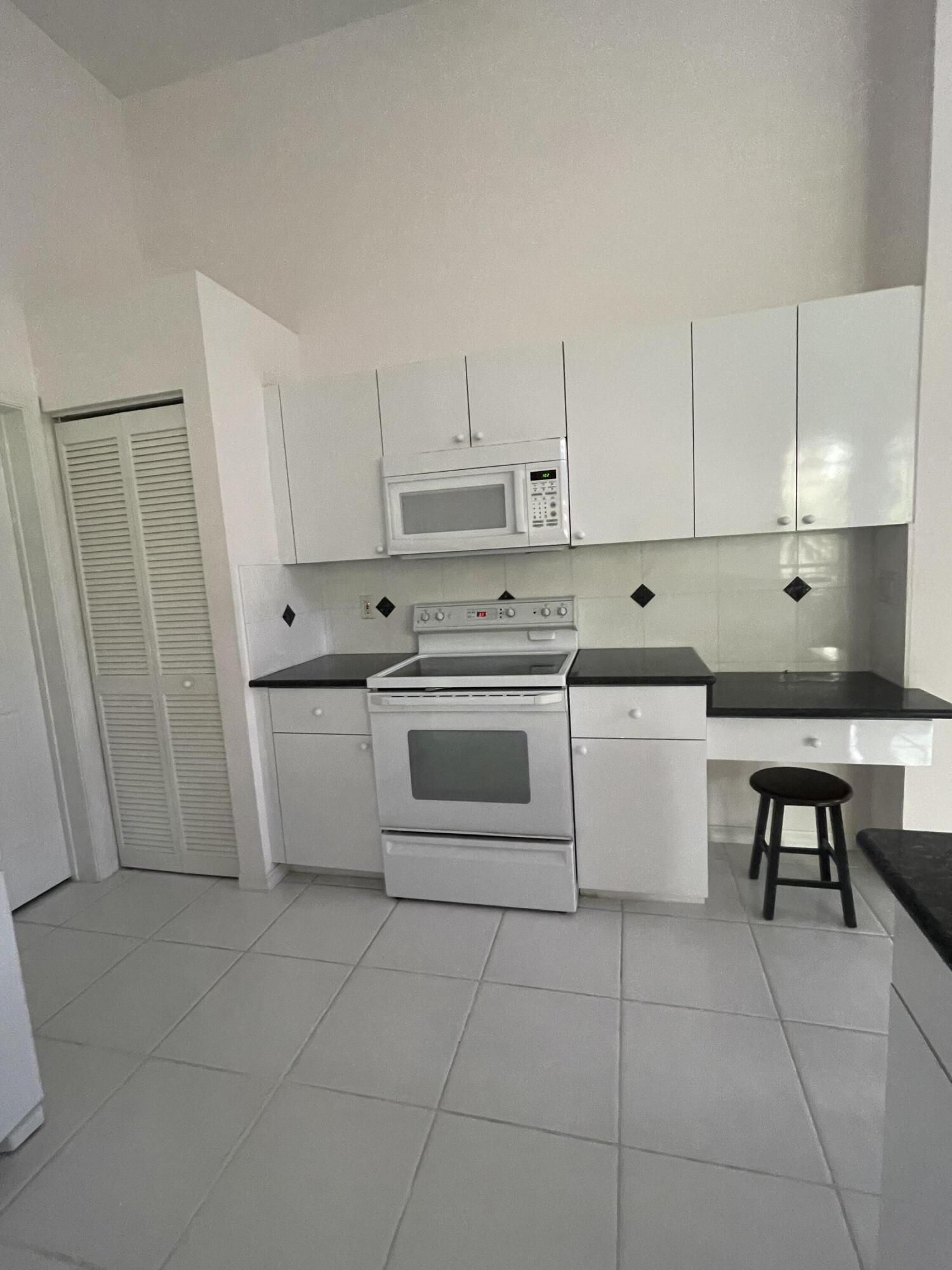 22324 Rushmore Place Boca Raton, FL 33428 - Photo 8 of 33 a kitchen with stainless steel appliances a stove a sink and white cabinets
