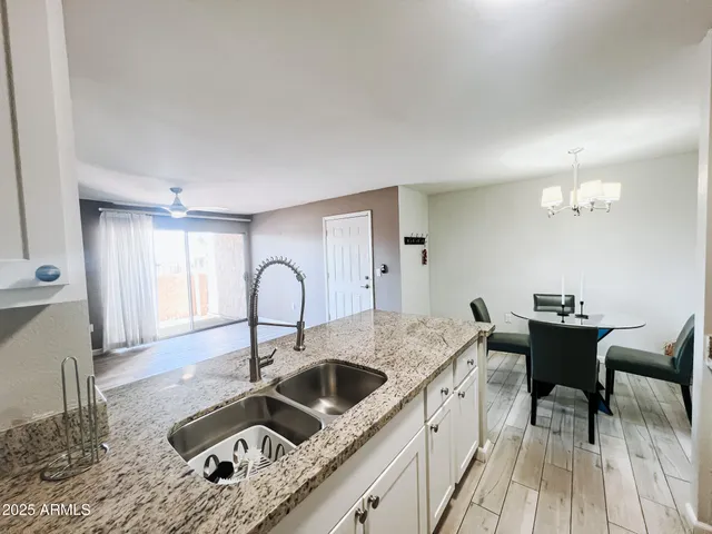 a kitchen with a stove a sink and dishwasher with wooden floor