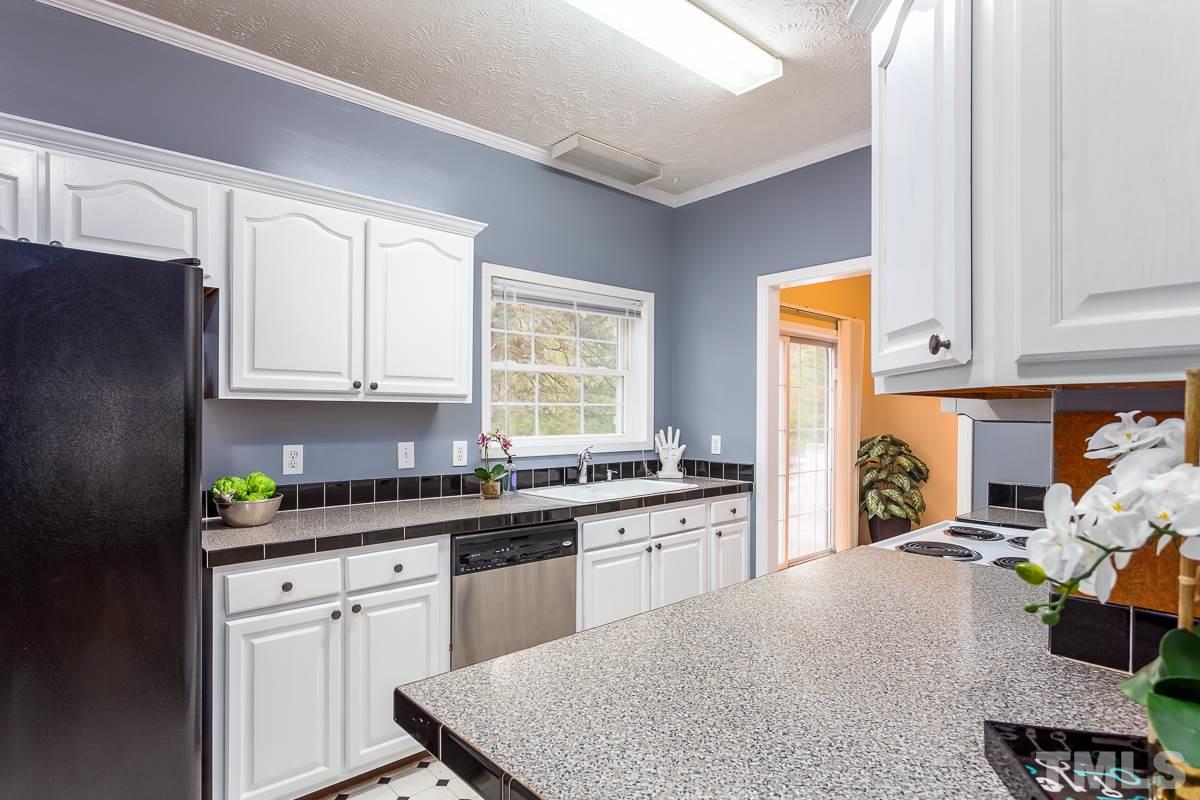 3882 Millard Whitley Road Chapel Hill, NC 27516 - Photo 9 of 20 a kitchen with stainless steel appliances granite countertop a stove a sink and a refrigerator