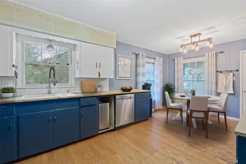 a large living room with stainless steel appliances granite countertop a sink dishwasher and wooden cabinets with wooden floor