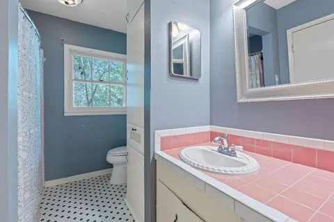a bathroom with a sink toilet and mirror